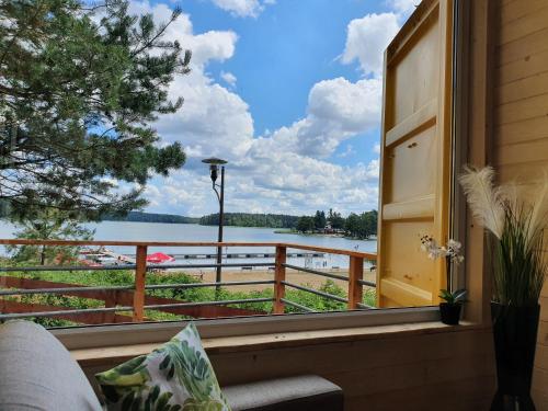 a window view of a lake from a house at Mazury Glamping in Orzysz