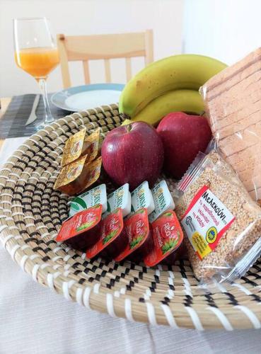 a basket of food with apples and bread and bananas at Afandou Square Apartment in Afantou