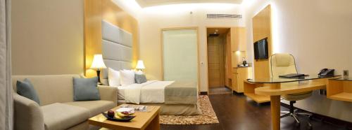 a hotel room with a bed and a desk at The Umrao in New Delhi