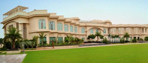a large house with a lawn in front of it at The Umrao in New Delhi