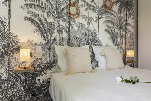 une chambre avec un lit avec un papier peint tropical dans l'établissement Bali Chic, à La Hourcade