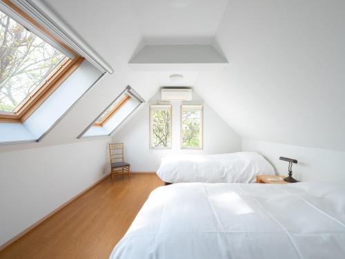 叶山町Hayama Isshiki Beach House -葉山 一色海岸の家 - ペット可的阁楼卧室设有两张床和两个窗户。