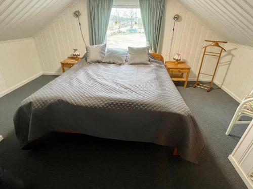 Cette chambre comprend un grand lit et une fenêtre. dans l'établissement Lilla Röda Huset., à Sjötofta
