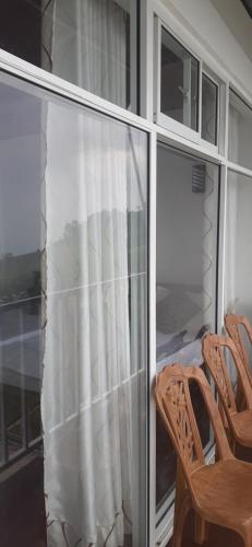 a screened in porch with two chairs and a window at Haputale Super View in Haputale