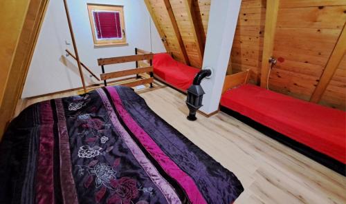 a bedroom with two beds and a red blanket at Sarajevo Chalet in Hadžići
