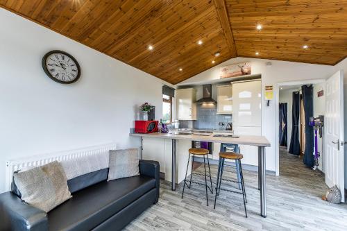 a kitchen and living room with a couch and a table at FAIRVIEW FARM Holiday Accommodation 14 Luxury Lodges, Cabins, Dog Friendly, Suitable for Couples, Families and Groups, Wedding Guests , Corporate events, Sleeps 2-65 guests in Ravenshead, Nottingham near Sherwood Forest, set in 88 acres in Nottingham