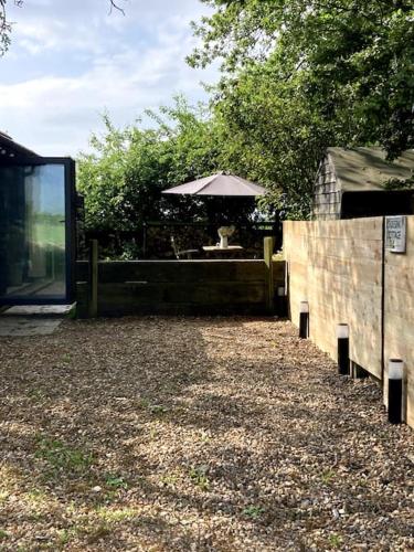 a patio with a table and an umbrella at Crossing Retreat - POOL table, PROJECTOR, BARN in Tunstead