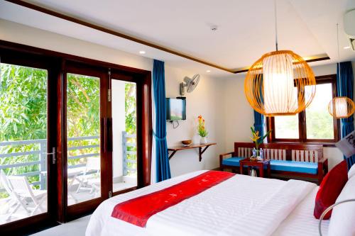a bedroom with a bed and a large window at Villa Loan A HOI AN in Hoi An