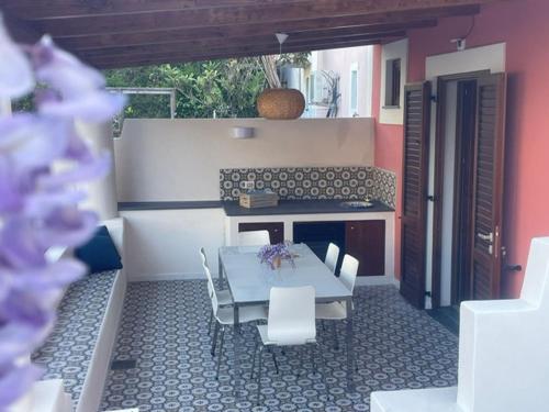 a patio with a table and chairs and a bench at Casa Grazia Apartments in Lipari