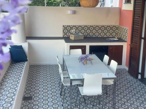 a table and chairs in a patio with a table and a counter at Casa Grazia Apartments in Lipari