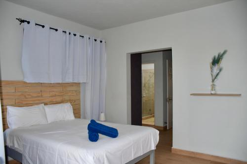 a blue object sitting on a bed in a room at Bel appartement proche de la plage Trou Aux Biches in Trou aux Biches