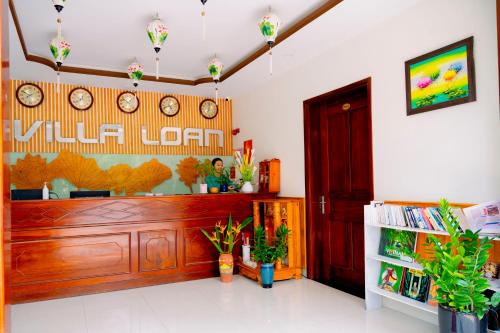 a lobby of a restaurant with clocks on the wall at Villa Loan A HOI AN in Hoi An