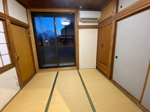 an empty room with a large window and a door at FTH Moon Light 3min to Sta. in Shimo-yoshida