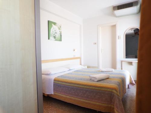 a bedroom with a bed in a room with a tv at Hotel Crystal in Rimini