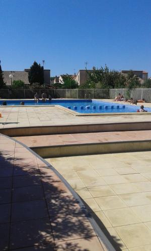 uma grande piscina com pessoas sentadas nela em au soleil de la grande bleue em Sainte-Marie-la-Mer