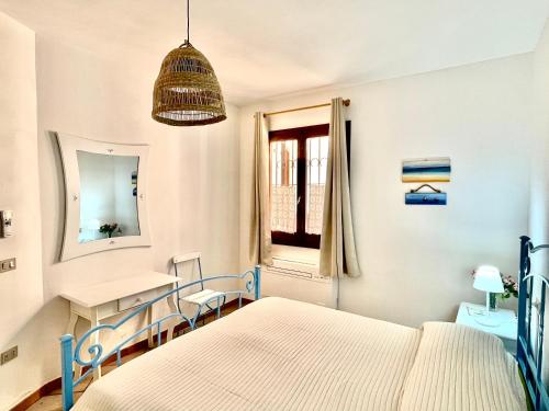 een slaapkamer met een bed, een bureau en een raam bij Casa vacanze Valledoria Q8732 in Valledoria