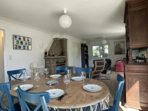 une salle à manger avec une table en bois et des chaises bleues dans l'établissement Maison bretonne 4 chambres proche bourg et plage, à Le Tour-du-Parc
