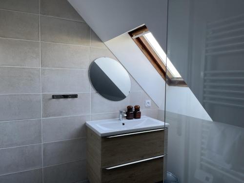 een badkamer met een wastafel en een spiegel bij Vancances relaxantes sur la Presqu ile de Rhuys in Le Tour-du-Parc