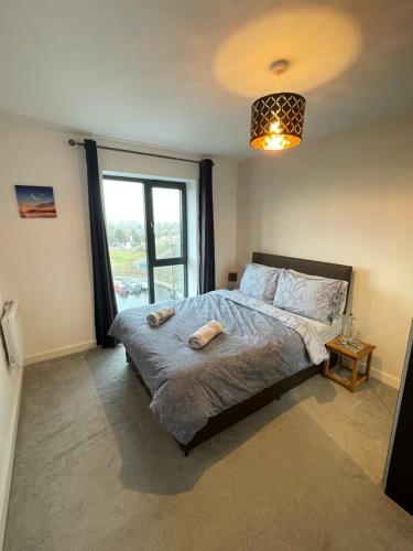1 dormitorio con cama y ventana grande en Balcony Marina Apartment With City Skyline Views en Mánchester