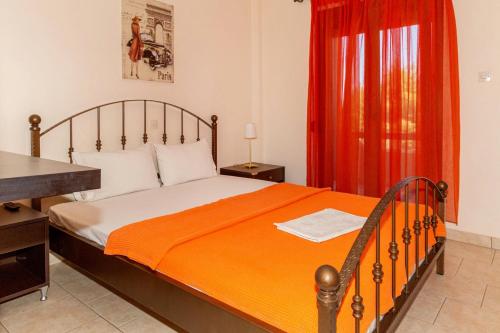 a bedroom with a bed with a desk and a red curtain at Pension Veria Frankfurt in Akti Salonikiou