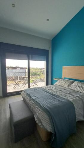 um quarto com uma cama e uma grande janela em Casa Rural Pozo Cinojal em Ahigal