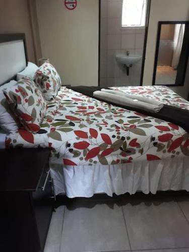 sypialnia z łóżkiem z czerwonym i białym kocem w obiekcie Manguzi Central Lodge w mieście Manguzi
