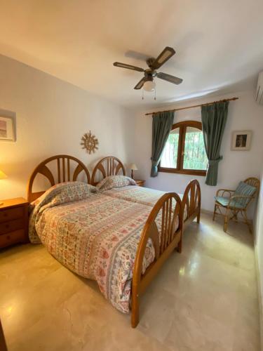 a bedroom with a bed and a ceiling fan at Superb villa with heated private pool - stunning sea and mountain views- Air con in Teulada