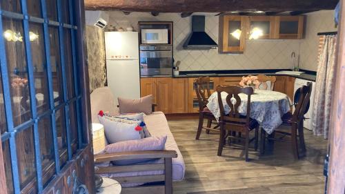a kitchen and a dining room with a table and chairs at La gallina in Arnés