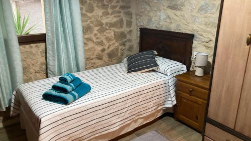 a bedroom with a bed with blue towels on it at La gallina in Arnés