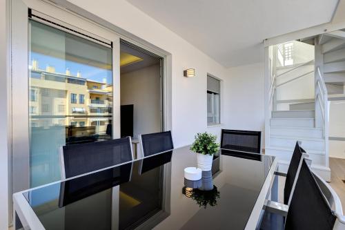 a dining room with a glass table and chairs at Aqua Apartments Vento, Marbella in Marbella