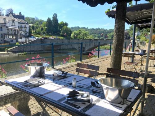 a picnic table with a blue table cloth and an umbrella at Le Berceau des Croisades in Bouillon