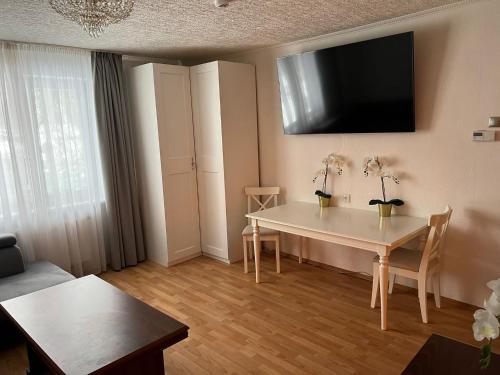 sala de estar con mesa y TV en la pared en Lake&Forest&City en Riga