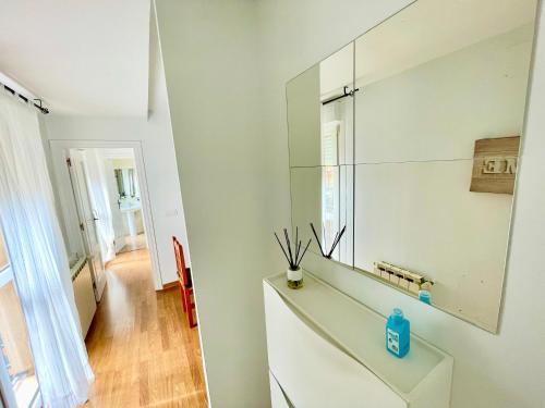 Baño blanco con espejo en la pared en Casa Pyrene - Acogedor apartamento familiar, en Sabiñánigo