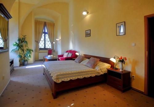 a bedroom with a bed and a couch in a room at Zamek Cerveny Hradek in Jirkov