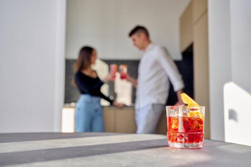 a man and a woman standing in a kitchen with a drink at Cà del Lasco - Free parking apartments 5 min from the station in Bellano