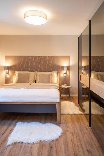 a bedroom with a large bed and a mirror at Appartements am Landschaweg in Weiz