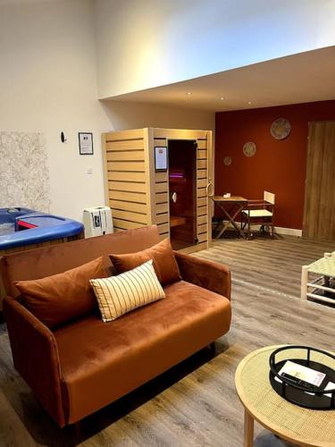 a living room with a couch and a table at La suite, avec jacuzzi & sauna in Muret