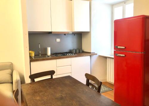 a kitchen with a table and a red refrigerator at Casa Tre Gradini in Perugia