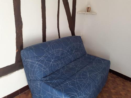une chaise bleue dans un coin de pièce dans l'établissement Les Kiwis, à Ponches-Estruval