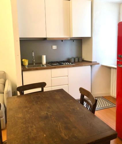 a kitchen with a wooden table and a kitchen with white cabinets at Casa Tre Gradini in Perugia