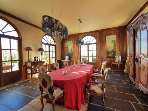 une salle à manger avec une table et des chaises rouges dans l'établissement Château de Lussac, à Lussac