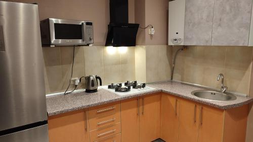 a small kitchen with a sink and a microwave at Mangali Apartment in Riga