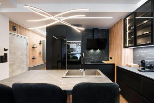 a kitchen with a sink and a ceiling fan at #Dahlia by halu! Apartments in Thessaloniki