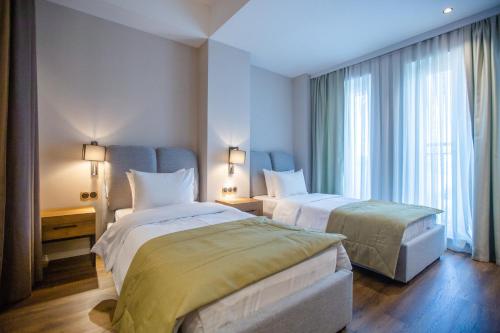 a hotel room with two beds and a window at Golden Horn Apart Hotel in Baku