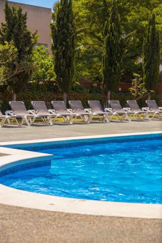 a row of lounge chairs next to a swimming pool at Camping Joncar Mar in Roses