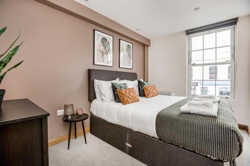 チャーツィーにあるHomely 2 beds apt up to 5 Guests-Wifi by Tent Serviced Apartmentsの大きなベッドと窓のある寝室
