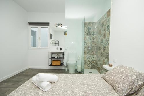 a white room with a bed and a bathroom at Los Alonsos - Open Mall - By AZ Rentals in Arrecife