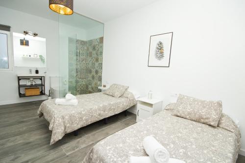 a bedroom with two beds and a mirror at Los Alonsos - Open Mall - By AZ Rentals in Arrecife