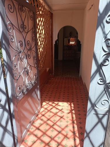 un couloir avec un portail en fer et une porte avec une fenêtre dans l'établissement Tiworgua, à Marrakech