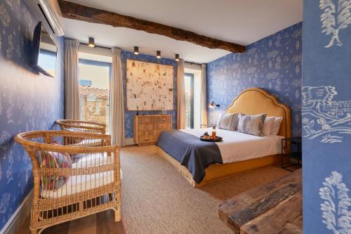 a bedroom with blue walls and a bed and chairs at THE PINTA Boutique in Armamar